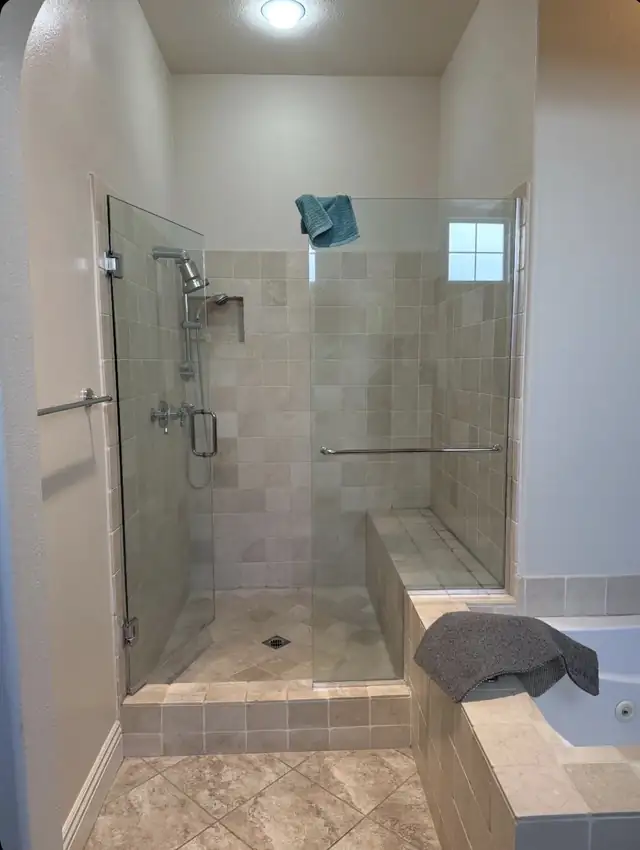 Glass-enclosed walk-in shower with handmade-look beige wall tile, a built-in bench and a raised tiled step